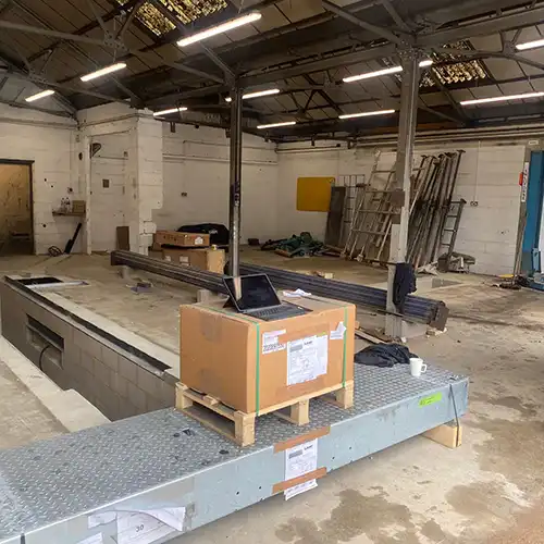 a warehouse with a conveyor belt and boxes on it
