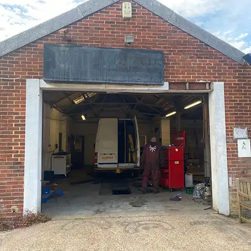 a man standing in a garage next to a truck
