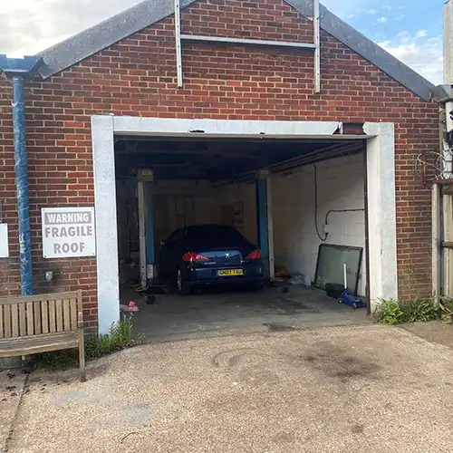 a car is parked in the garage of a brick building